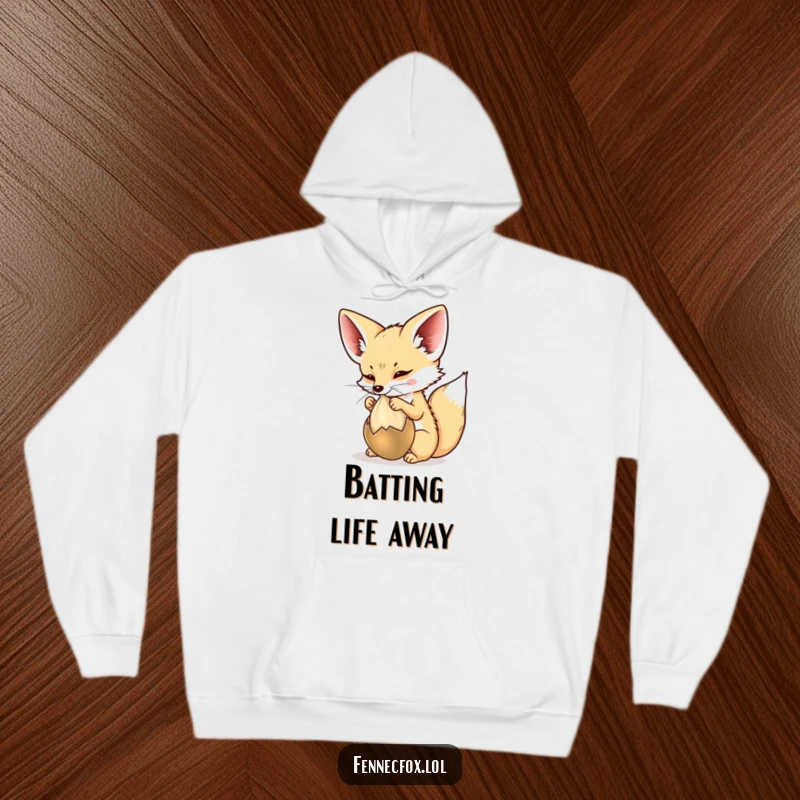 Funny Hoodie with a fennec fox playfully batting at a seed pod, offering cozy comfort and whimsical desert-themed humor.