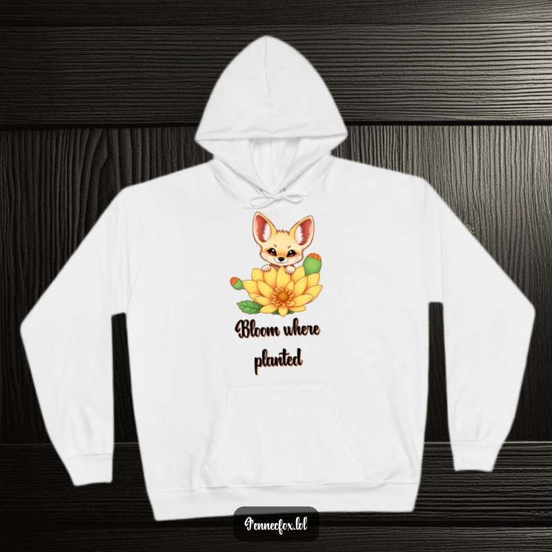 Funny cheerful fennec fox peeking curiously over a vibrant, oversized desert flower, depicted on a warm and cozy hoodie. A humorous choice.