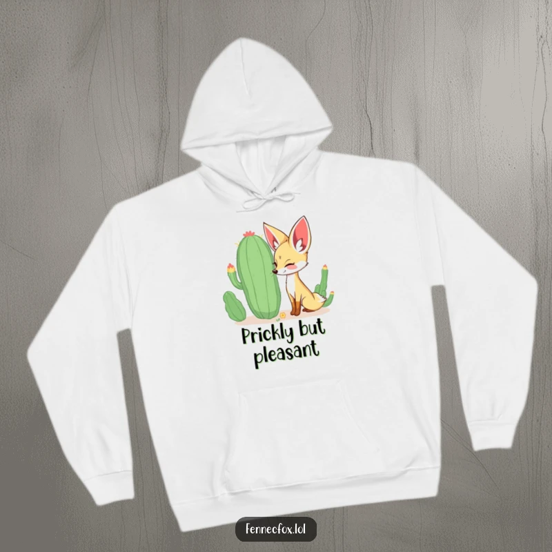 Funny curious fennec fox sniffing a large, whimsical cactus with a happy expression, depicted on a warm and cozy hoodie. A humorous choice.